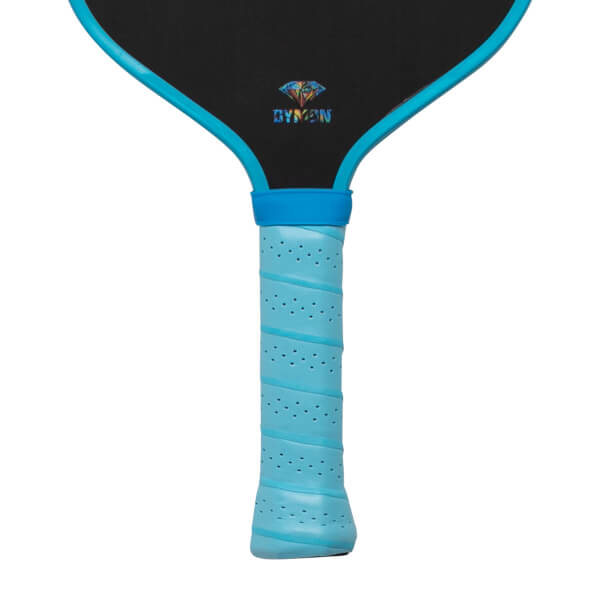 Close-up view of the black paddle face and light blue perforated handle featuring a bright blue rim and the colorful DYMON logo with a diamond icon.