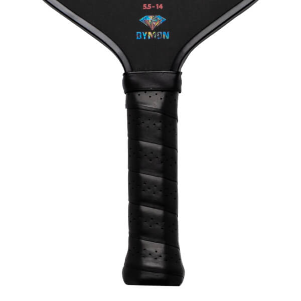 Close-up of a black pickleball paddle grip with perforations and the "DYMON" logo.