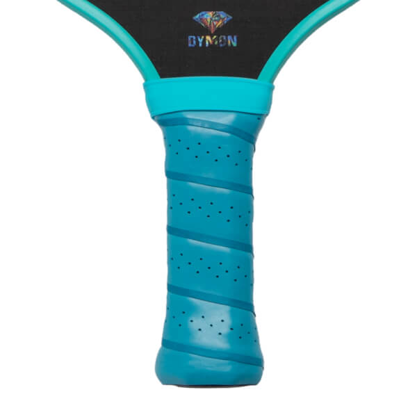 Close-up of the teal perforated grip handle and the bottom of the black paddle face featuring a multicolored diamond logo and the word DYMON.
