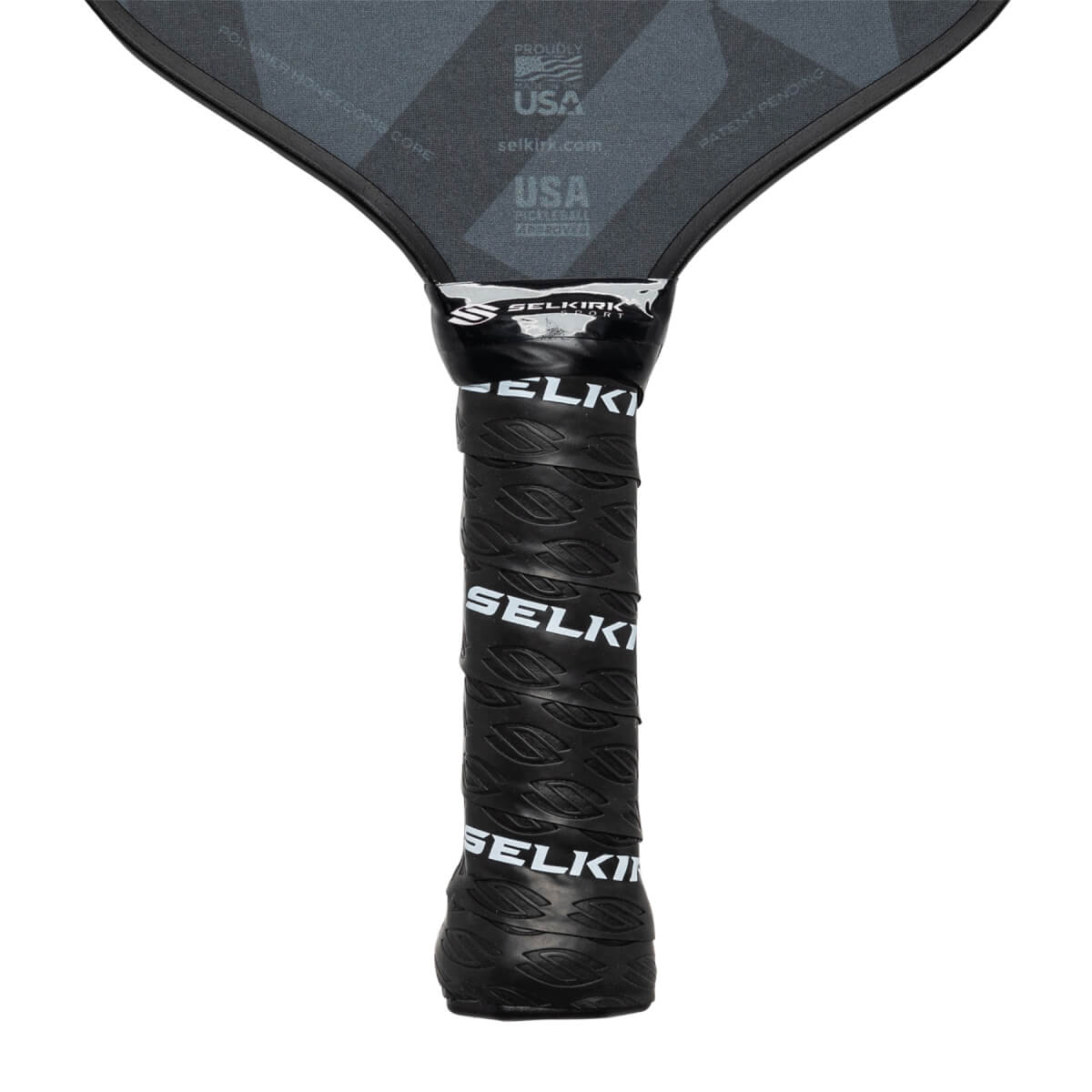 Close-up of a black pickleball paddle grip with Selkirk branding and a textured pattern.