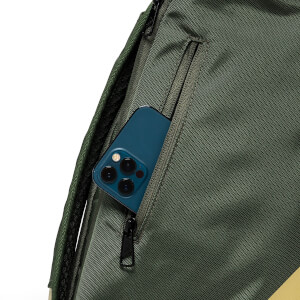 Close-up view of the green backpack featuring a blue smartphone partially tucked into a vertical zippered side pocket.
