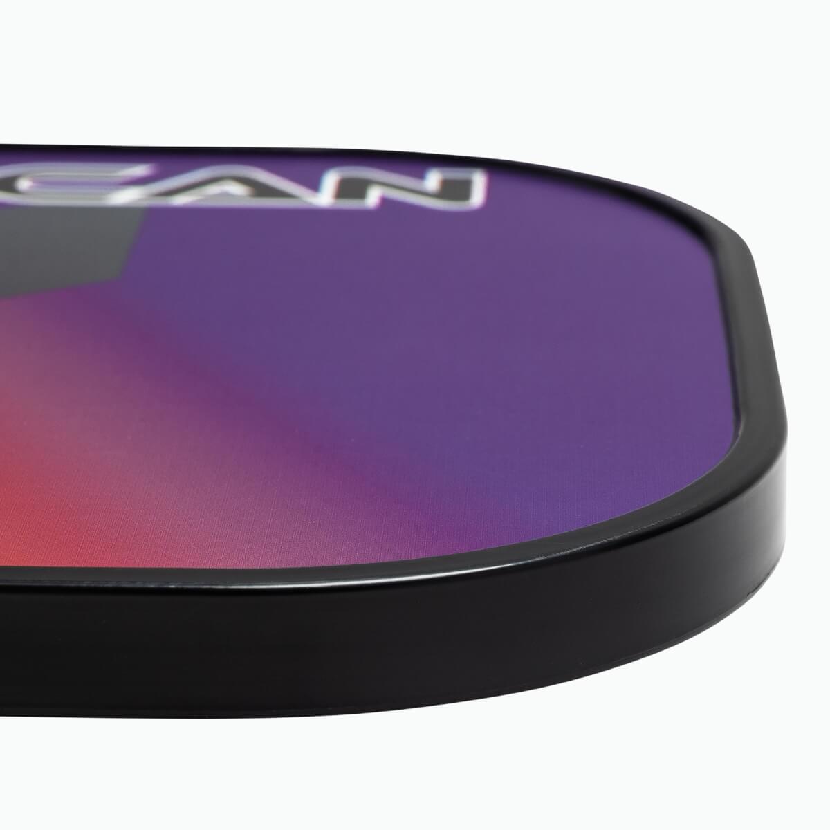 Corner view of a purple and pink pickleball paddle with black trim and visible CAN text.