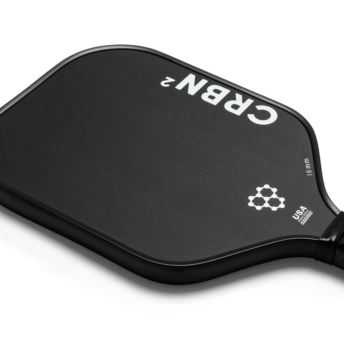 Top-down view of a black pickleball paddle with white CRBN² branding and a USA Pickleball Approved logo.