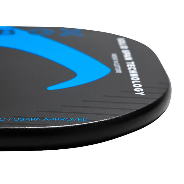 Corner view of a black pickleball paddle with blue accents, USAPA APPROVED text, and CARBON SPIN TECHNOLOGY text.
