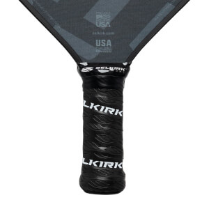 Close-up of a black pickleball paddle grip with Selkirk branding and leaf pattern.