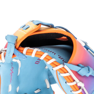 Close-up of a blue baseball glove with orange lacing, featuring "Dream Big" text and a gradient of pink and purple on the back.