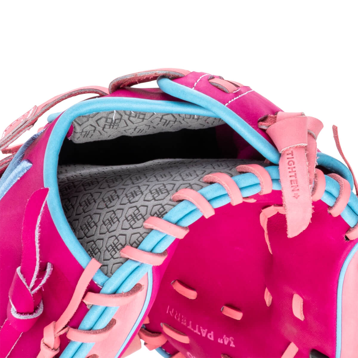 Close-up of a pink and blue baseball glove showing the "34" PATTERN" text and a "TIGHTEN" strap.