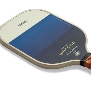 Corner view of a tan pickleball paddle with a blue gradient and Warstic branding.