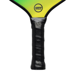 Close-up of a black pickleball paddle grip with perforated texture and a yellow USAPA Approved logo on the paddle head.