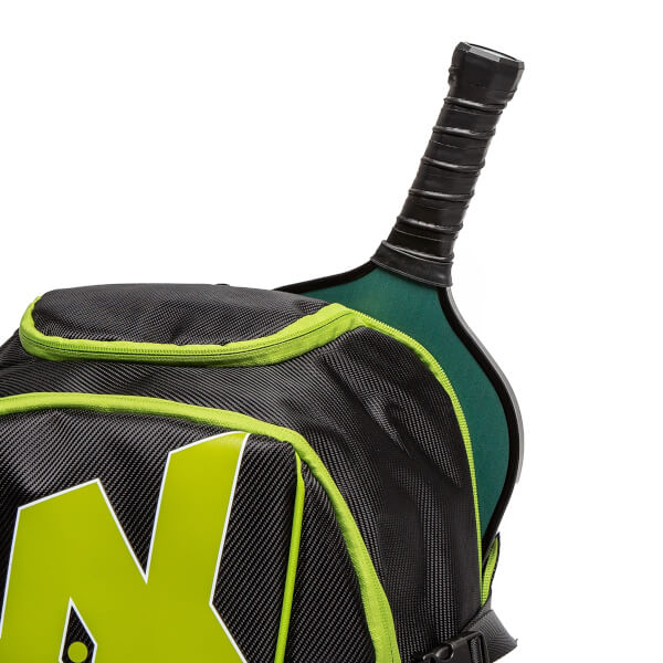 Close-up of a black pickleball backpack with green trim and a black pickleball paddle handle.