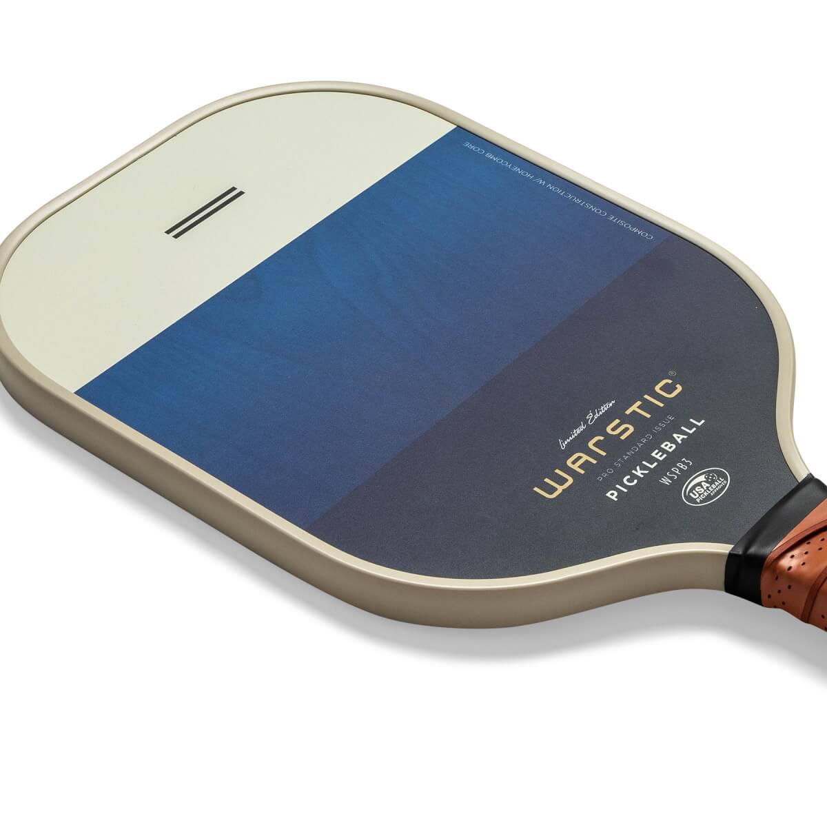 Corner view of a tan pickleball paddle with a blue gradient and Warstic branding.