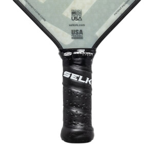 Close-up of a black pickleball paddle grip with SELKIRK SPORT and SELK branding, and USA PICKLEBALL APPROVED text.