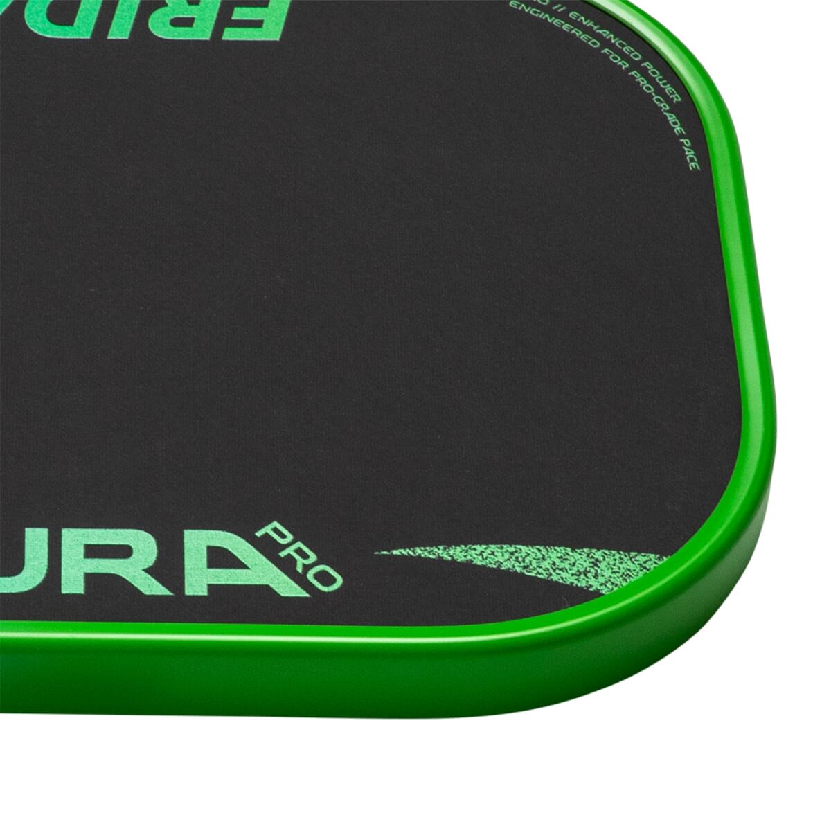 Close-up of a black textured pickleball paddle with a green rounded edge and AURA PRO.