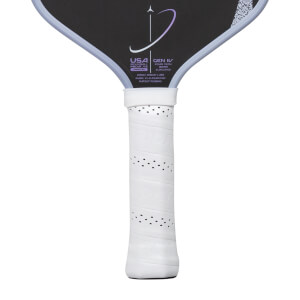 Close-up of a white and black pickleball paddle with a perforated grip, USA text, and a purple graphic.