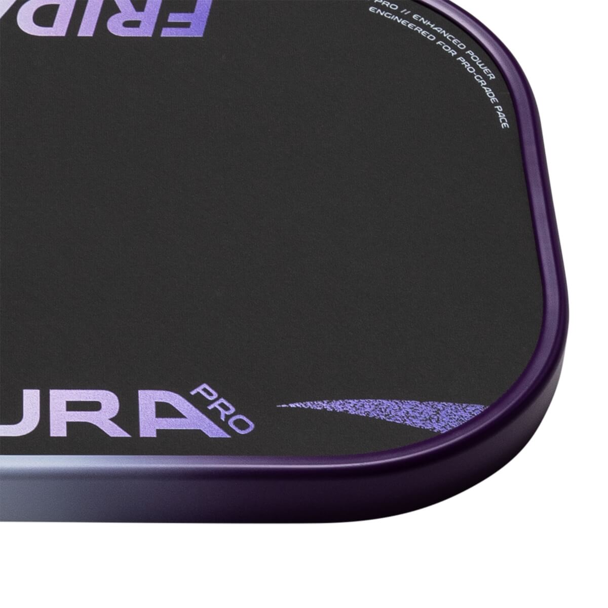 Close-up of a black pickleball paddles bottom right corner with a purple edge guard, AURA PRO text, and speckled design.
