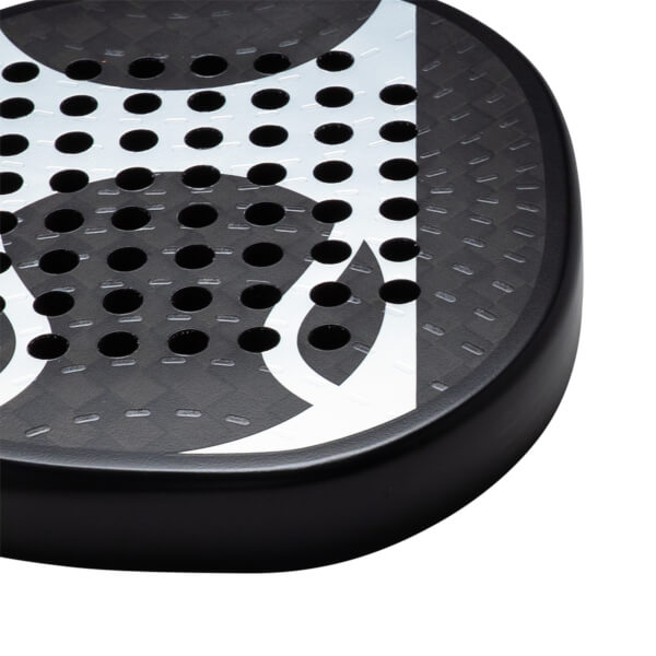 Corner view of a black paddle with white abstract design and circular holes.