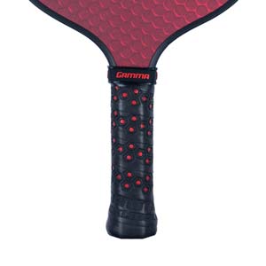 Close-up of a black pickleball paddle grip with red hexagonal pattern and GAMMA logo.