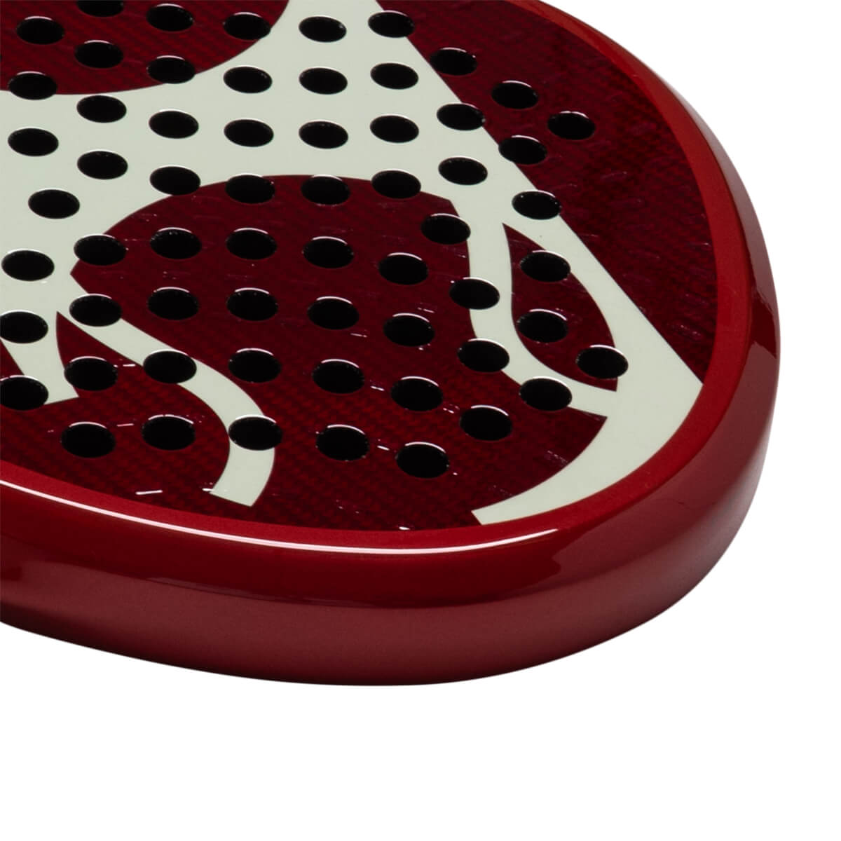 Corner view of a red padel racket with white abstract design and black circular holes.