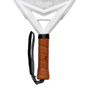 Close-up of a white padel racket handle with brown grip, black cord, and "GAMMA PADEL" text.