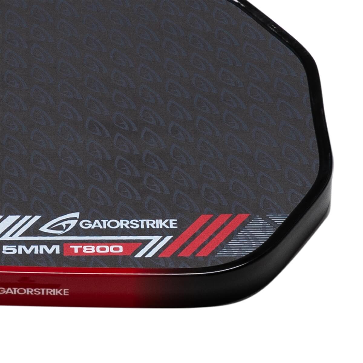 Close-up of a black pickleball paddle corner showing GatorStrike branding, 15MM T800 text, and a textured face pattern.