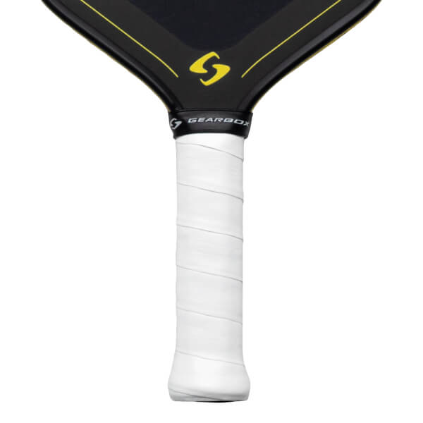 Close-up of a pickleball paddle handle showing white grip tape with embossed "GEARBOX" text and the black neck with yellow accents and a yellow "S" logo.