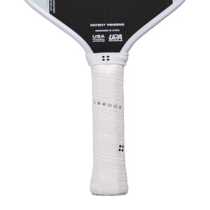 Close-up of a white pickleball paddle grip with LBROOK text and the black paddle face showing PATENT PENDING.