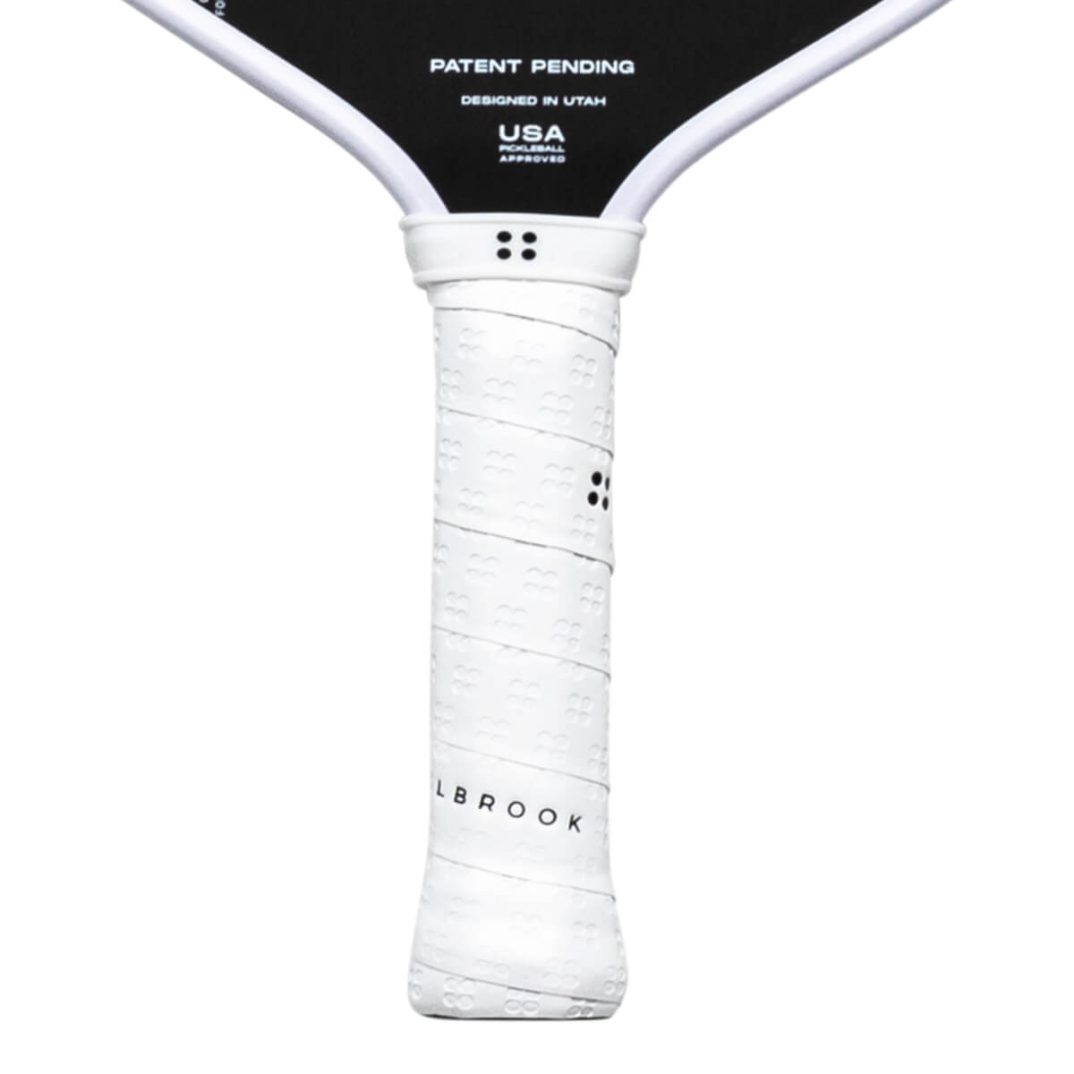 Close-up of a white pickleball paddle grip with embossed pattern and "LBROOK" text.