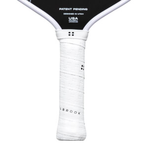 Close-up of a white pickleball paddle grip with embossed pattern and "LBROOK" text.