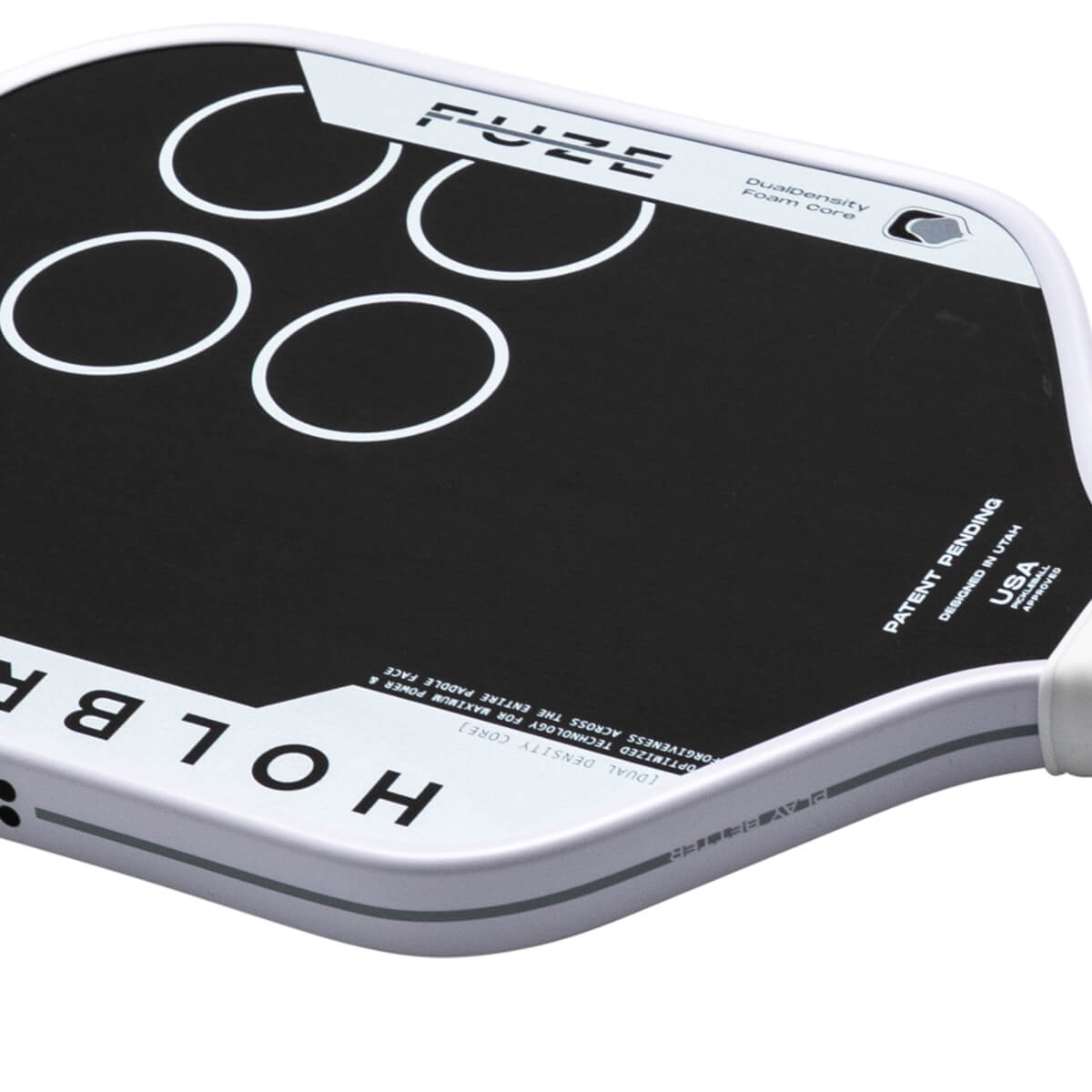 Top-down view of a black pickleball paddle with white circles and the word "FUZE" printed on it.