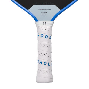 Close-up of a white perforated pickleball paddle handle with blue neck and ROOK HOL text.
