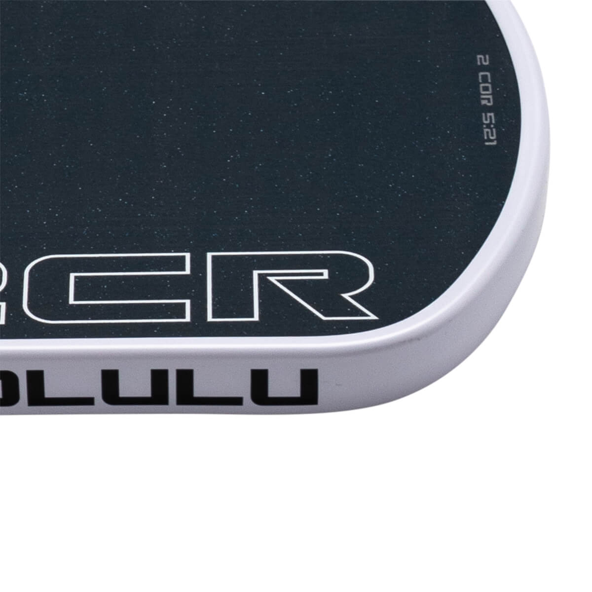 Close-up of a rounded corner featuring a black deck with "CR" and "2 COR 5:21" text above a white side rail with "LULU" printed in black.