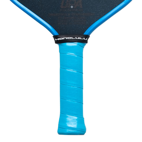 Close-up view of a pickleball paddle handle featuring a light blue grip wrap and a black throat band with "HONOLULU" in white text.