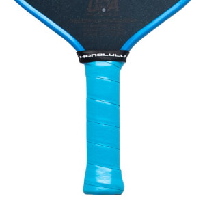 Close-up view of a pickleball paddle handle featuring a light blue grip wrap and a black throat band with "HONOLULU" in white text.