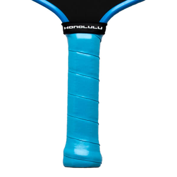 Close-up of a blue pickleball paddle grip with "HONOLULU" in white text on a black band.