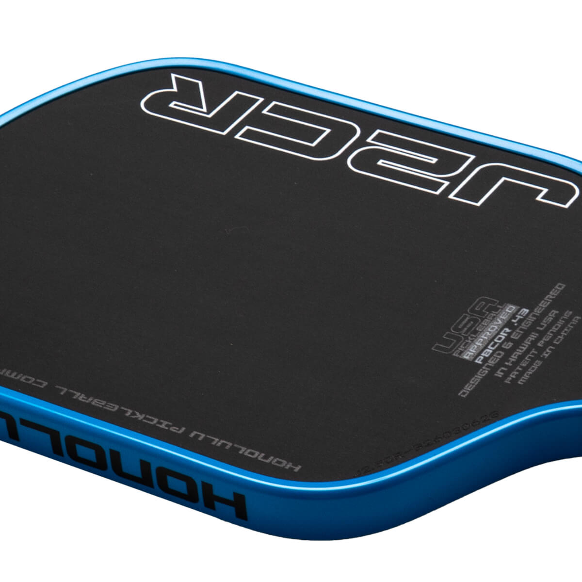 Corner view of a black pickleball paddle with a blue edge, showing the white "JCR" logo and "HONOLULU PICKLEBALL" text.