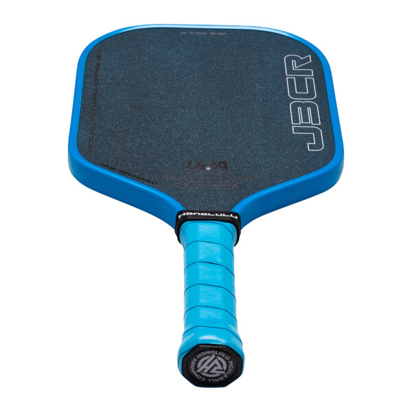 Top-down view of a blue pickleball paddle with a dark textured surface, showing the "JBCR" logo and "HONOLULU PICKLEBALL COMPANY" text.
