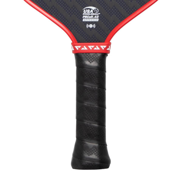 Close-up of a black pickleball paddle handle with a textured grip, red throat trim, and USA Pickleball approval logo.