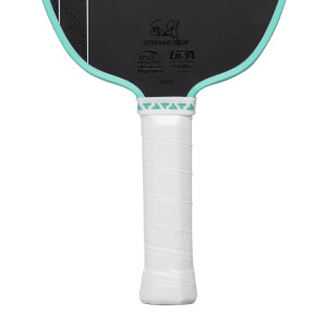 Close-up of a black pickleball paddle with a white wrapped grip, teal edge, and STEFANIE GRAF signature.
