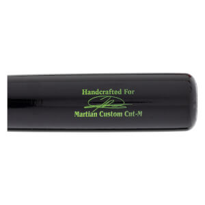 Close-up of a black baseball bat with green Handcrafted For text, a green signature graphic, and Martian Custom Cut-M text.
