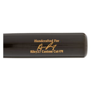 Close-up of a black baseball bat with gold Handcrafted For text, a signature, and Riley27 Custom Cut-YM branding.
