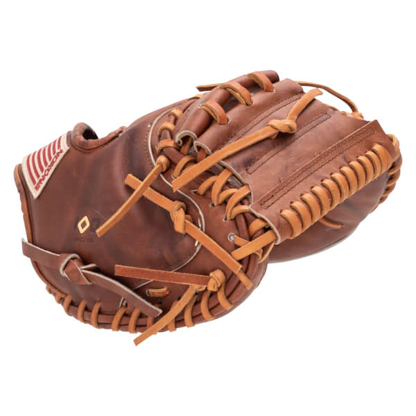 Side view of a brown leather baseball glove with tan lacing and an American flag patch with "NOXON" text.