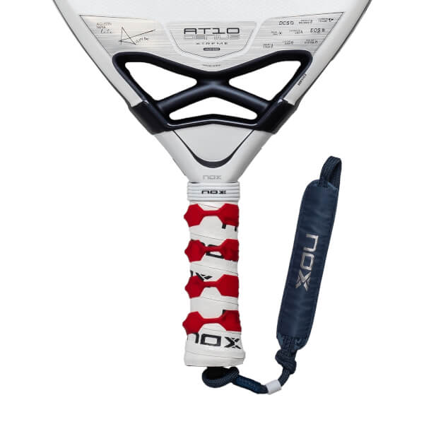 Close-up of the NOX AT10 GENIUS padel racket handle and throat, featuring a white grip with red inserts and a blue NOX branded wrist strap.