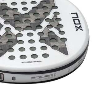 Close-up angled view of a white NOX Genius padel racket head featuring circular holes, a carbon fiber X pattern, and prominent NOX and GENIUS branding.