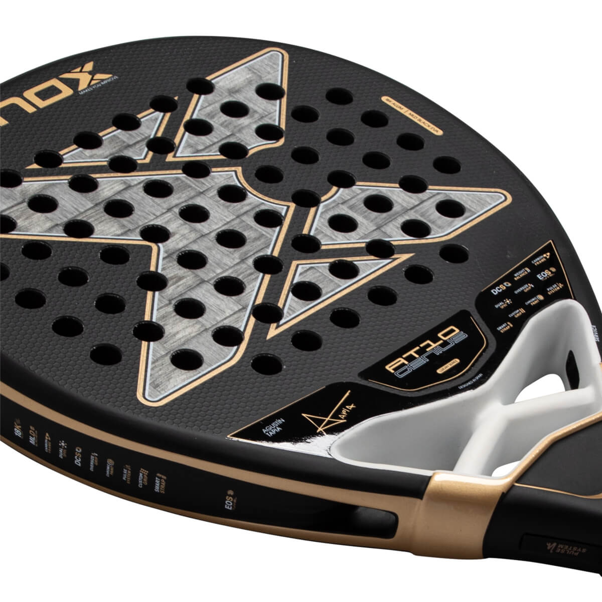 Angled close-up of the Nox AT10 Genius padel racket head featuring a black honeycomb face, a large gray X logo, and gold "AT10 GENIUS" and "AGUSTÍN TAPIA" branding.
