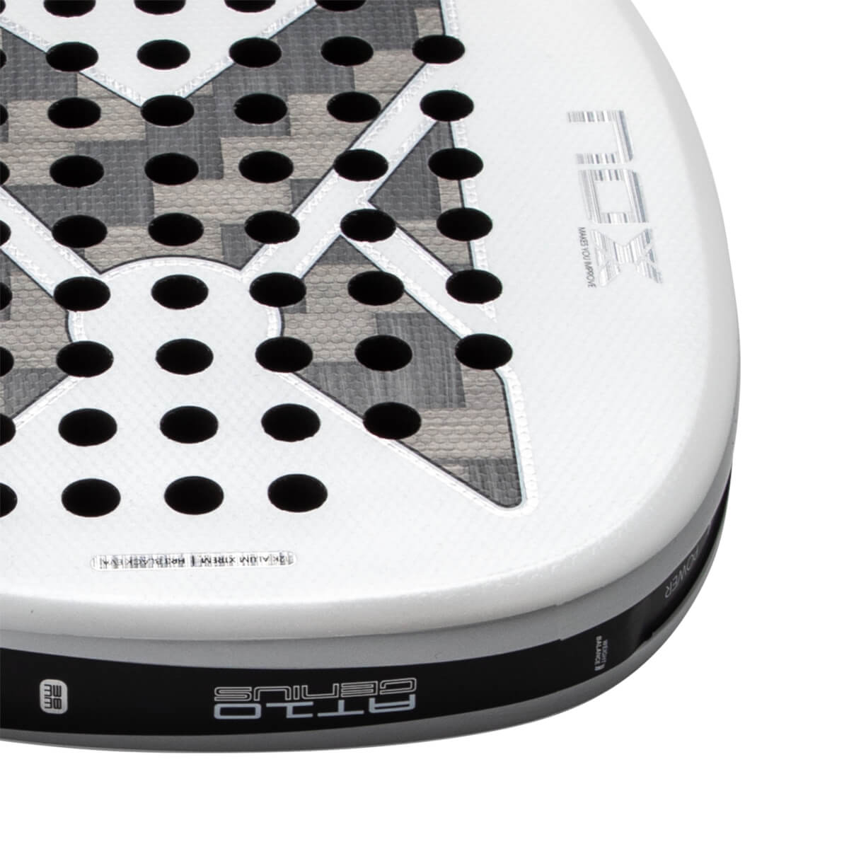 Close-up corner view of a white padel racket featuring a gray patterned 'X' over a perforated face with 'NOX' branding and 'AT10 GENIUS' text on the side edge.