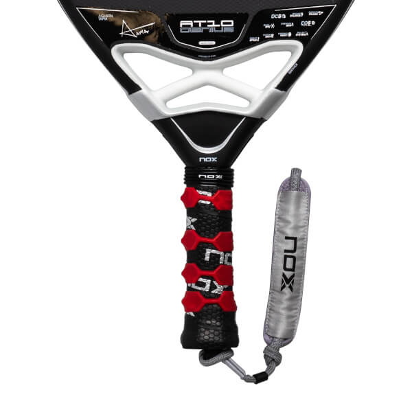Close-up of a black padel racket with AT10 GENIUS on the face, a red and black grip, and silver NOX strap.