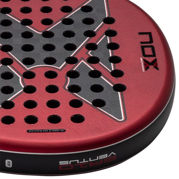 Close-up of the red and black textured padel racket face displaying the NOX and VENTUS logos, perforated holes, and 12K XTREM text along the rim.