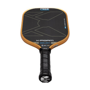 Front view of the Nox X-Foam Goldin paddle featuring a black face with a gold frame, large "X-FOAM" and "GOLDIN" text, and a perforated black grip.