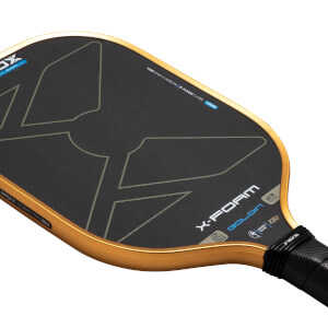 Angled close-up of the Nox X-Foam Goldin pickleball paddle featuring a black T700 raw carbon face with gold edges and prominent "X-FOAM GOLDIN" branding.