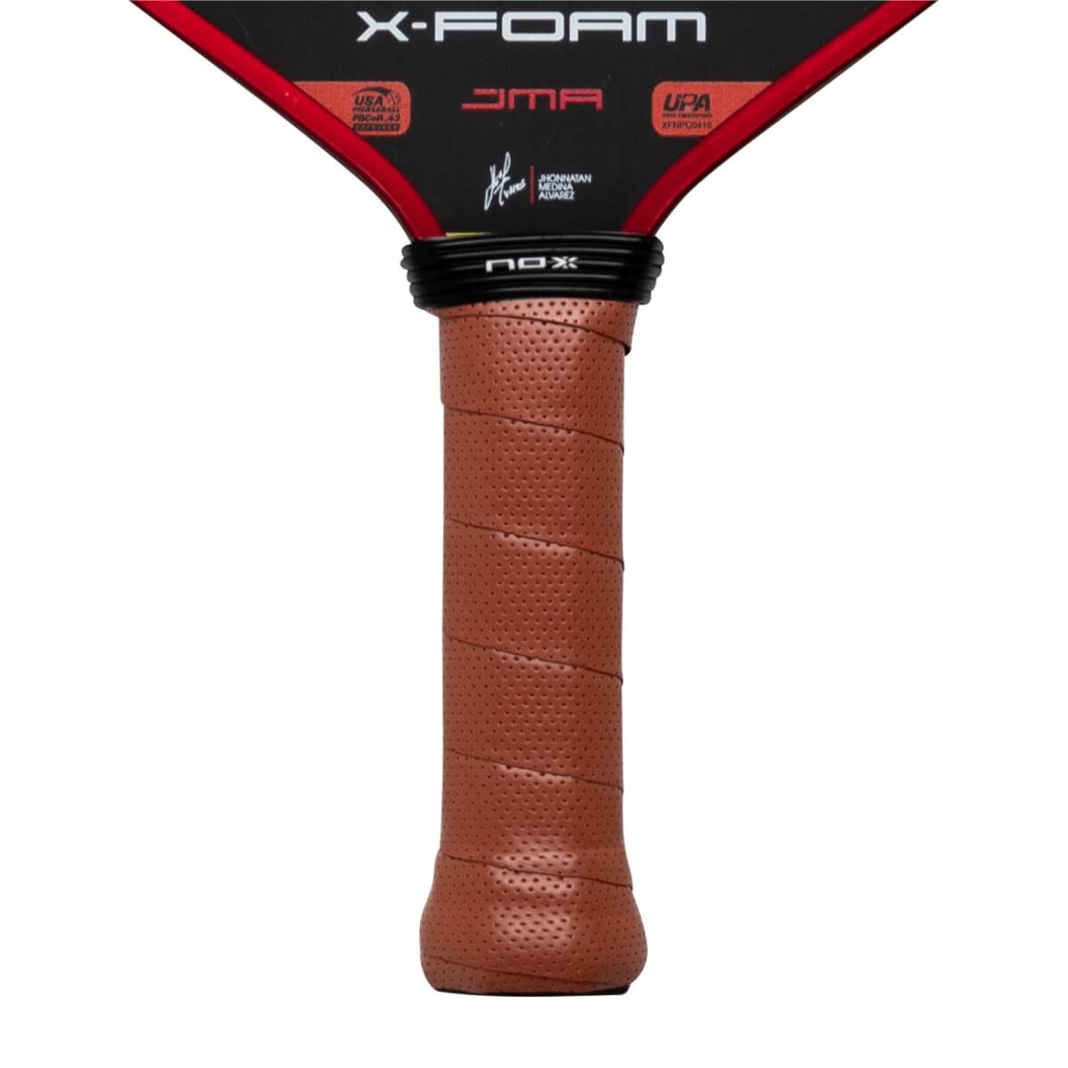 Close-up of the brown perforated handle and black neck featuring the NOX logo, with X-FOAM and JMA text visible on the black and red lower face of the paddle.
